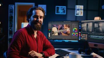 Portrait of happy videographer using professional software to create visual effects for video projects. Smiling expert using post production techniques to edit raw clips footage, zoom in shot photo