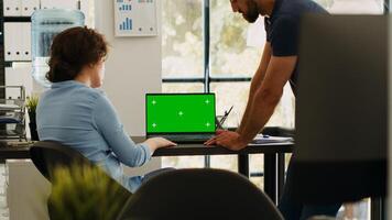 Business team analyzing greenscreen on laptop display, brainstorming new ideas and working on startup operations. Coworkers discussing about partnership, blank copyspace template. photo