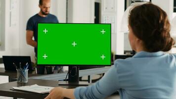 Manager working with isolated greenscreen on computer at workstation, looking at chromakey display with mockup template on desk. Businesswoman using pc in coworking space. photo