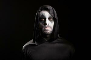 Portrait of man wearing demon make up for halloween party isolated over black background. photo