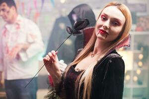 mujer vistiendo un vampiro disfraz mirando a el cámara para Víspera de Todos los Santos celebracion. foto