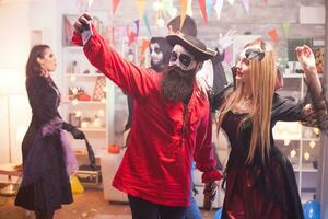 Beautiful young man and woman in halloween costumes taking a selfie. photo