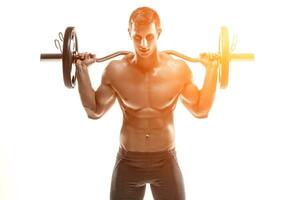 Strong man exercising fitness body building exercises with a barbell photo