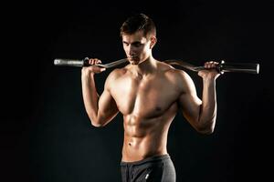 Strong man holding barbell on his shoulders, photo