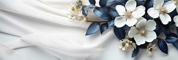 AI generated Close up white flowers and navy silk on white fabric background. Flat lay top view composition with copy space for banner, card photo