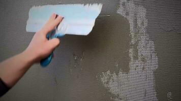 The final stage of plastering the walls. A worker levels the plaster with a metal spatula. Of Painter's Hand Puttied Wall Using A Paint Trowel. video