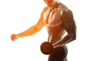 Athletic man showing muscular body and doing exercises with dumbbells photo