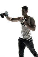 Muscular man doing exercises with dumbbells isolated on white background photo