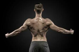 Rear view of muscular man with his arms stretched out photo