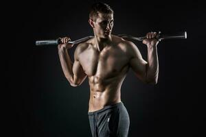 Strong man holding barbell on his shoulders, looking to side photo