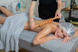 joven mujer consiguiendo un espalda masaje en un spa salón. belleza tratamiento concepto. foto