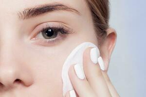 Woman using cotton pad photo