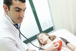 médico en un médico oficina es visitando un bonito mujer con un estetoscopio foto