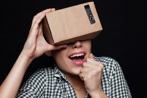 Color shot of a young woman looking through cardboard photo