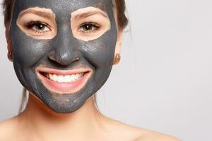 Portrait Of Beautiful Girl Removing Cosmetic Black Peeling Mask photo