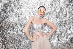 Young beautiful girl on a silver background. photo