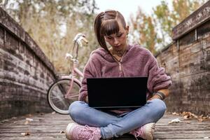 young woman studying with computer sitting on a table photo