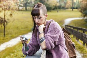 pretty girl taking photographs from a wooden bridge photo