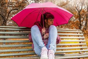 young woman sheltering from the autumn rain photo