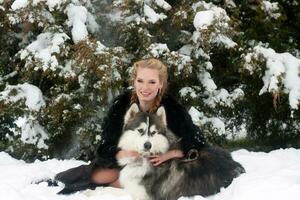 Young woman with wolf dog in snow photo