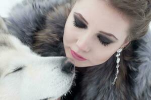 Young woman with wolf dog in snow photo