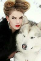 joven mujer con lobo perro en nieve foto