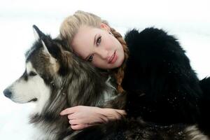 joven mujer con lobo perro en nieve foto