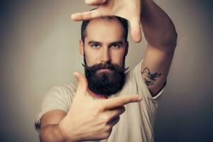 Young cheerful photographer with beard, while working studio photo