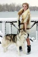 joven mujer con lobo perro en nieve foto