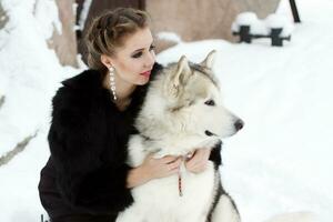 Young woman with wolf dog in snow photo