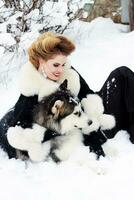 joven mujer con lobo perro en nieve foto