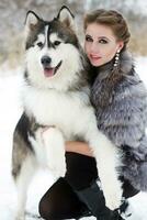 joven mujer con lobo perro en nieve foto