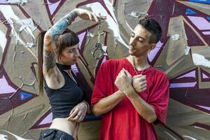 young couple tattooed boyfriends playing with handcuffs photo