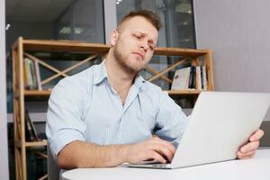 young businessman his desk looking sadly photo