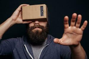 Color shot of a young man looking through card board photo