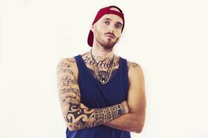 tatuado rap cantante posando en estudio en un blanco antecedentes foto
