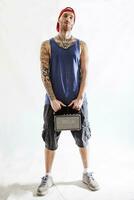 tattooed rap singer posing in studio with an amplified radio photo