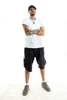 tatuado rap cantante posando en estudio en un blanco antecedentes foto