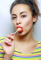 beautiful girl with candy on a stick photo