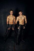 Two young muscular men black background photo