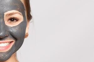 Portrait Of Beautiful Girl Removing Cosmetic Black Peeling Mask photo