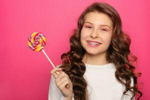 Woman with dental braces holding lollipop photo