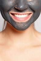 Portrait Of Beautiful Girl Removing Cosmetic Black Peeling Mask photo