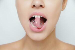 Beautiful woman sticking out her tongue and showing young piercing photo