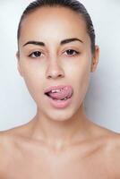 hermosa mujer sacando la lengua y mostrando piercing joven foto