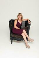 Portrait of a stunning fashionable model sitting in a chair photo