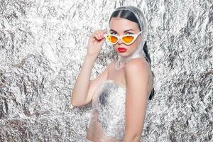 Young beautiful girl on a silver background. photo