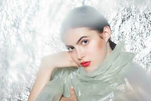 Young beautiful girl in a black dress on a silver background. photo