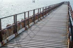 old rusty wooden pier to the sea photo