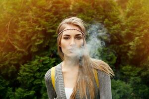 Happy vaping young white blonde girl photo